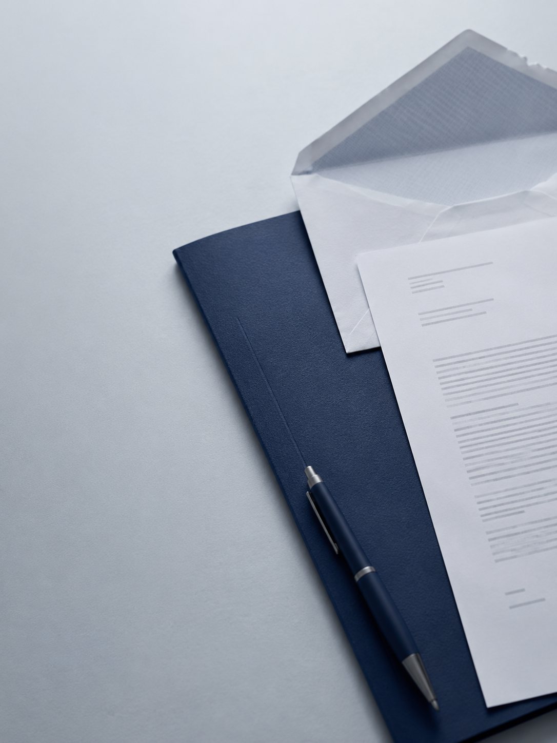 Formal correspondence resting over a navy document folder on a desk, with a pen nearby, suggesting a serious matter requiring attention.